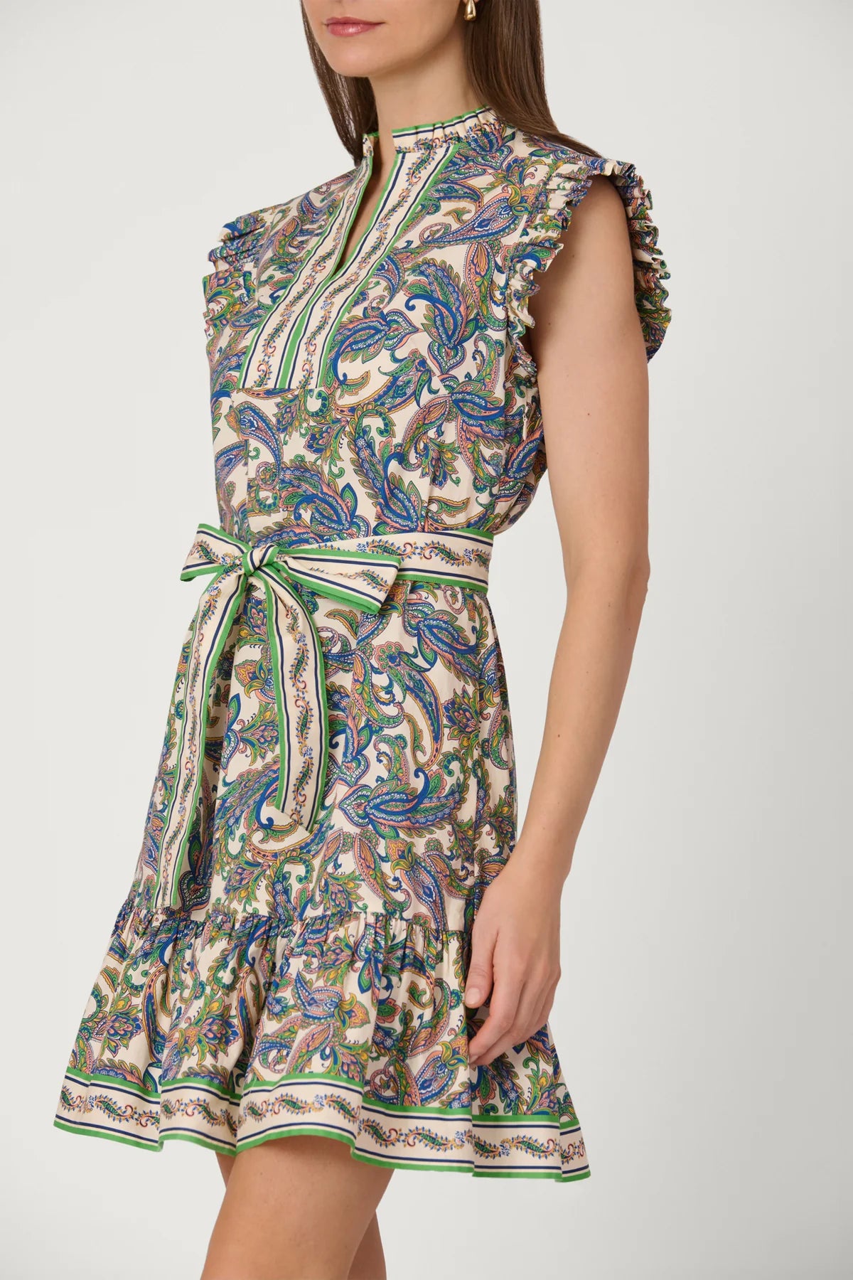 Woman wearing a sleeveless patterned dress on a white background