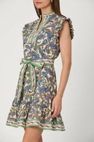 Woman wearing a sleeveless patterned dress on a white background