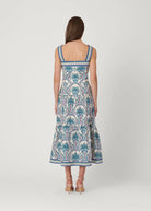 Woman wearing a palm tree patterned dress on a white background