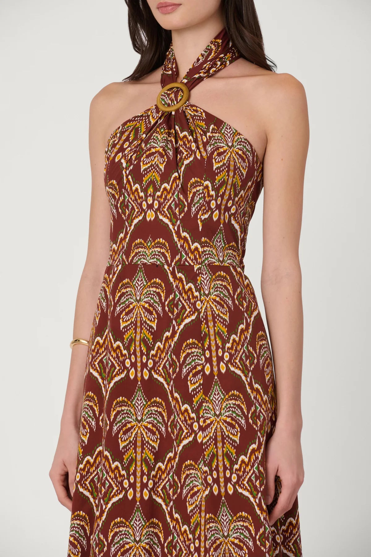 Woman wearing a patterned halter neck dress on a white background