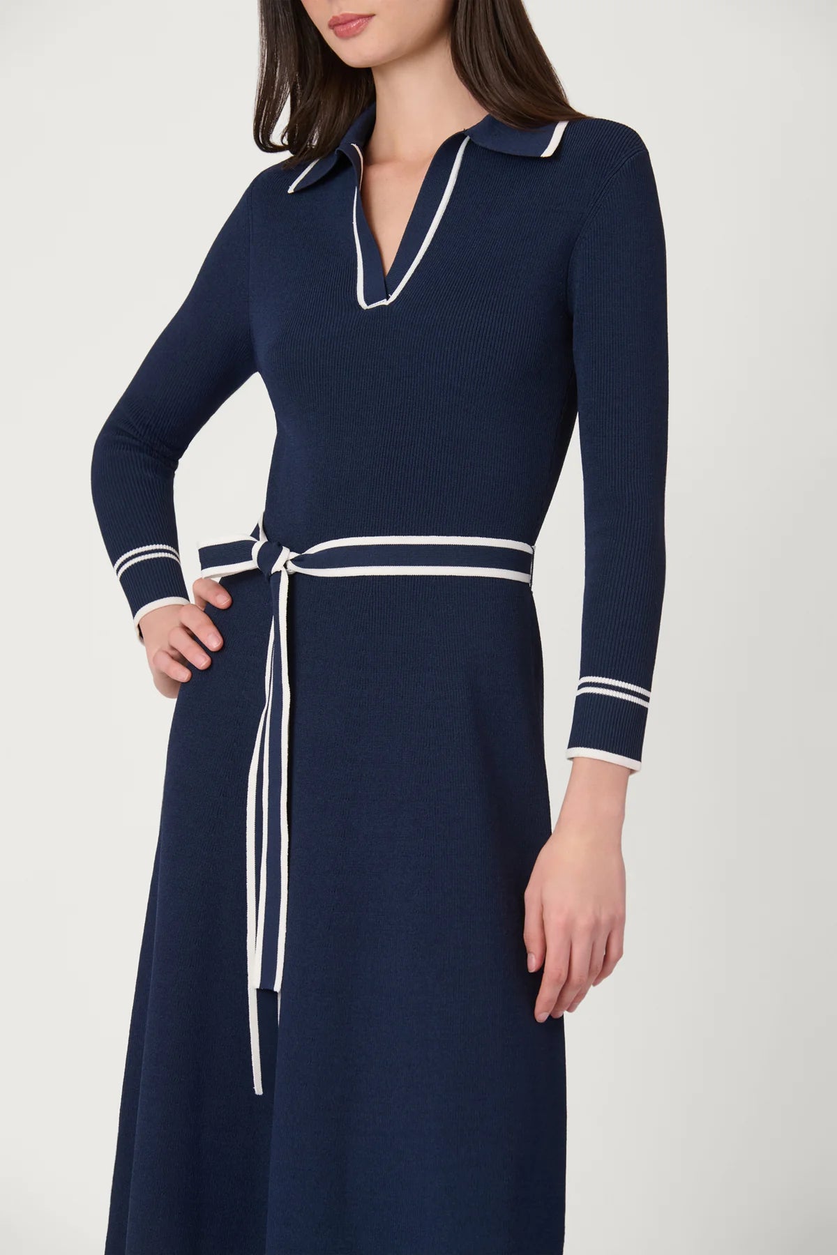 Navy dress with white accents on a plain background