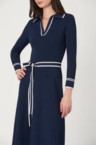 Navy dress with white accents on a plain background