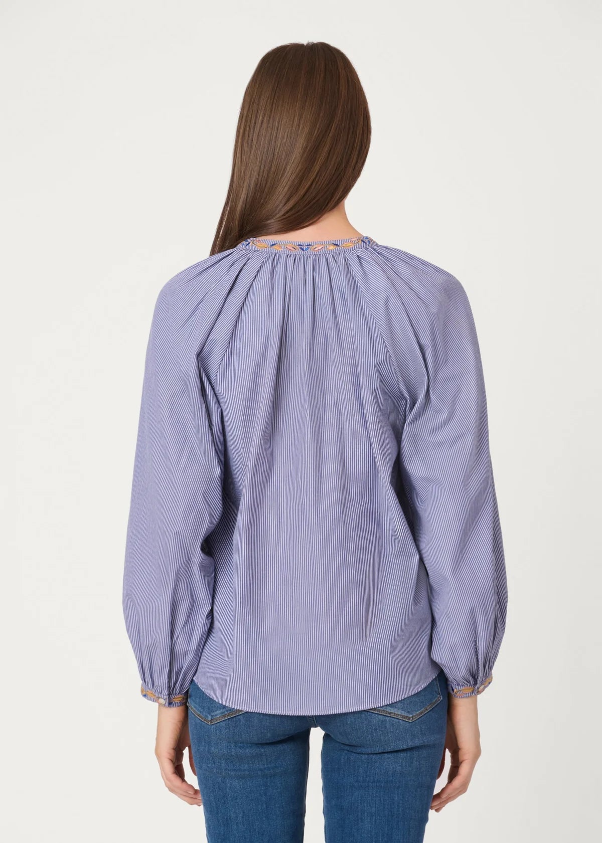 Woman wearing a light purple blouse with long sleeves on a white background