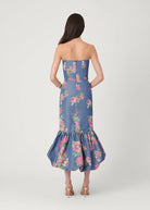 Woman wearing a strapless floral dress with a white background