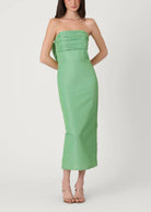 Woman wearing a strapless green dress on a white background