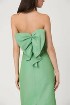 Green strapless dress with a large bow detail on the back against a plain background