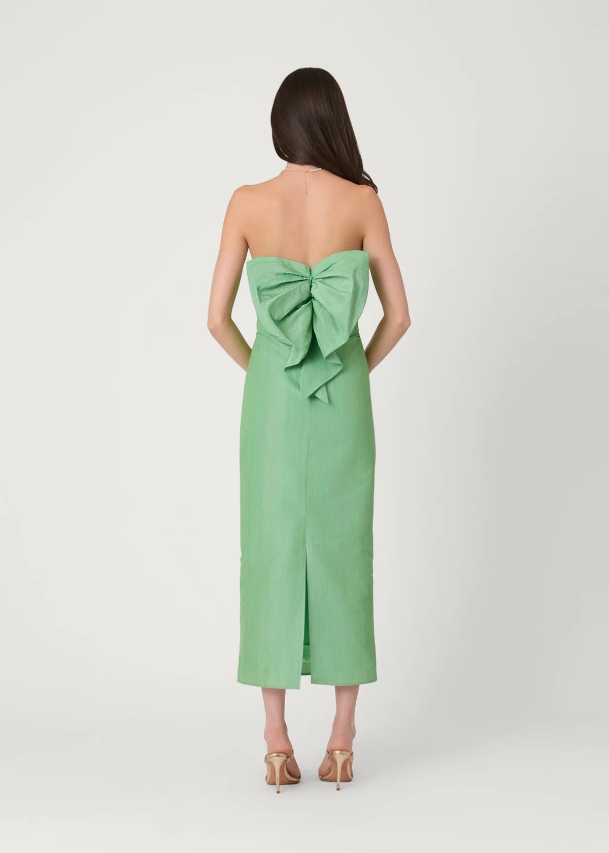 Green strapless dress with a large bow detail on a white background