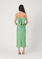 Green strapless dress with a large bow detail on a white background