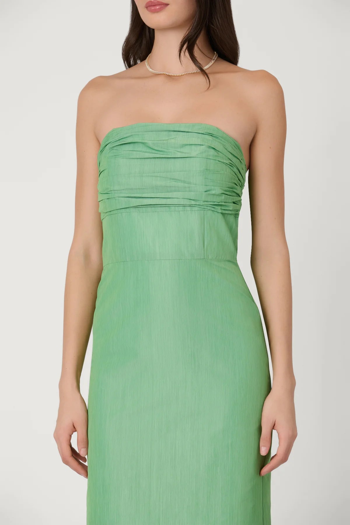Green strapless gown on a white background