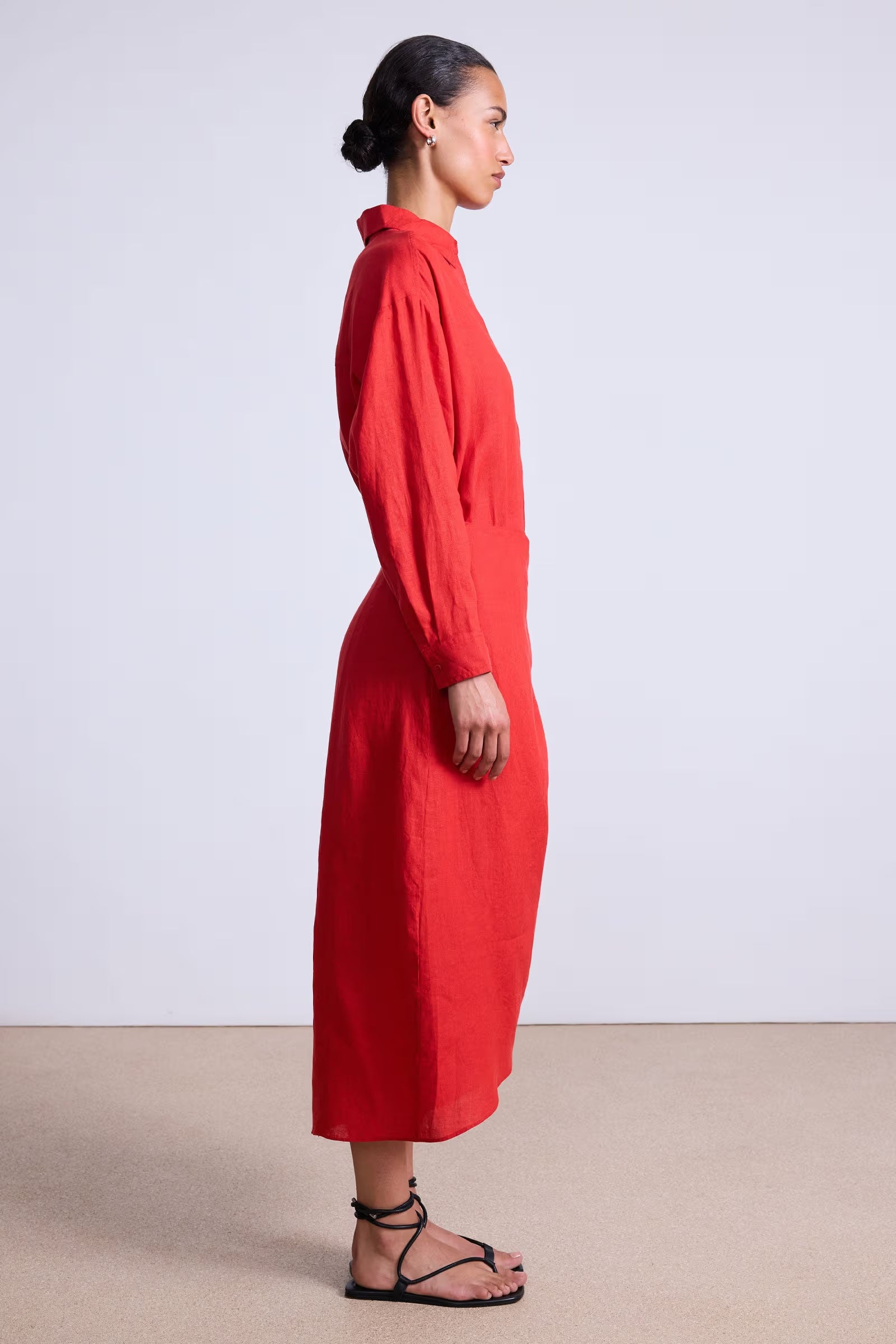 Woman wearing a red dress standing against a white background