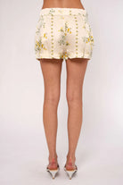Floral shorts worn by a person on a plain background