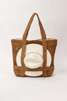 Woven brown tote bag with a white cushion inside on a light gray background