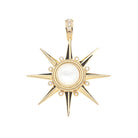 A gold starburst pendant featuring a central white pearl surrounded by small clear stones, with a bail set with clear stones at the top, shown on a plain white background.