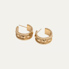 Gold hoop earrings on a light beige background