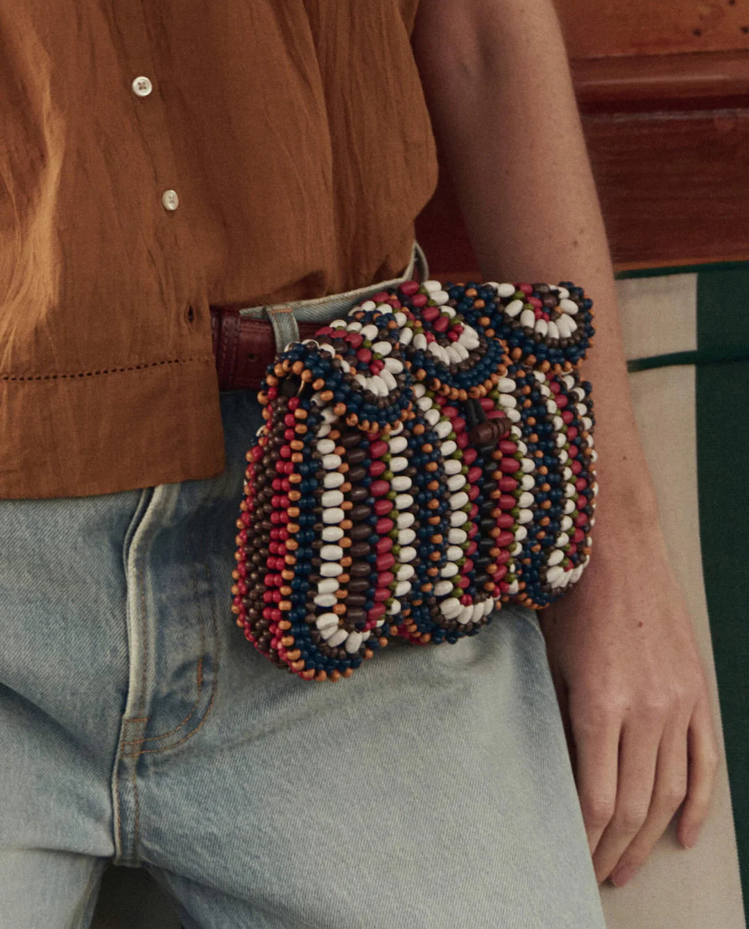 Person wearing a colorful beaded bag over their shoulder with a blurred background