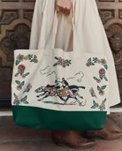 Tote bag with horse and floral design held by a person wearing a white coat.