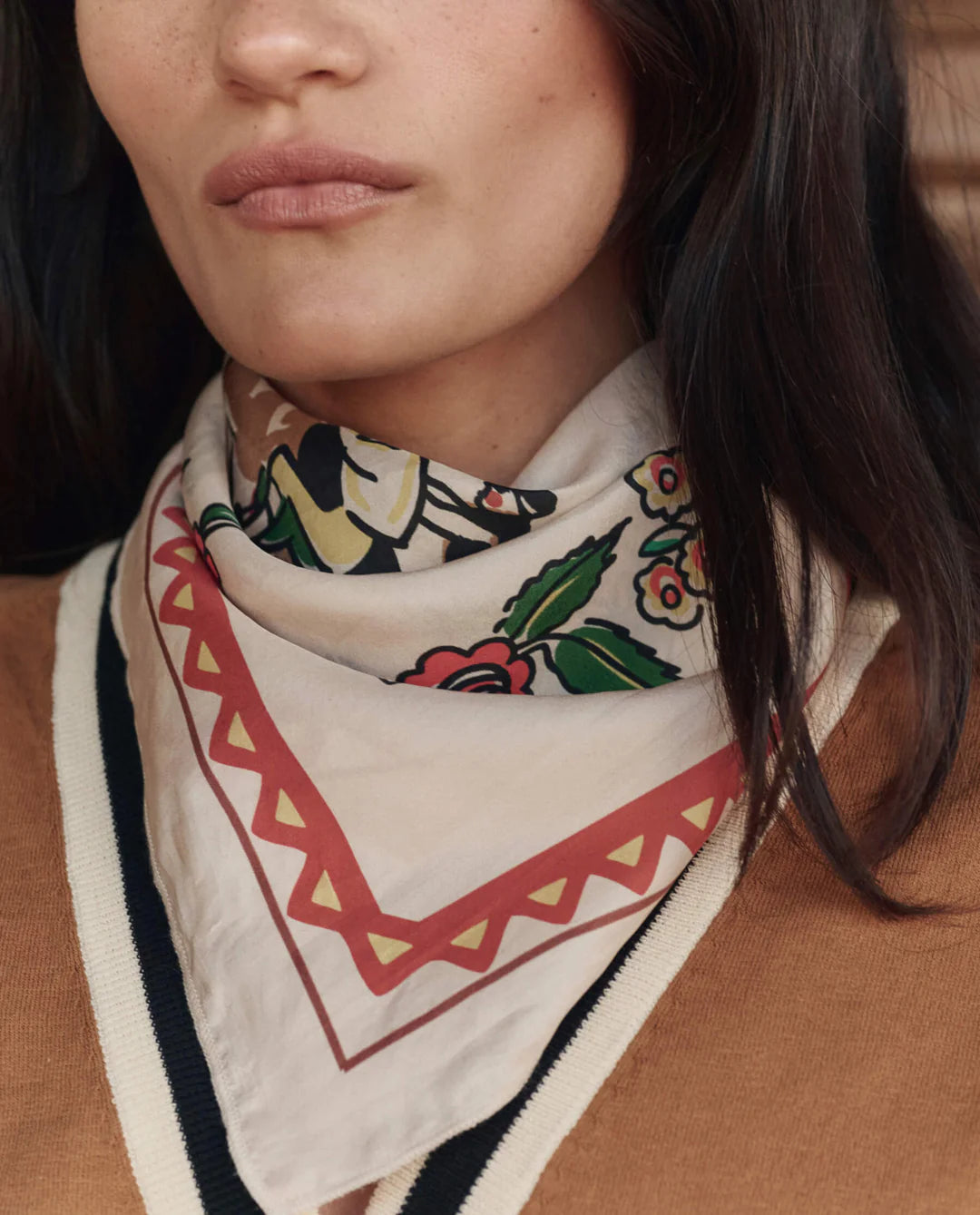 Person wearing a patterned scarf with a neutral background