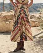 Person wearing a colorful striped dress in a desert setting