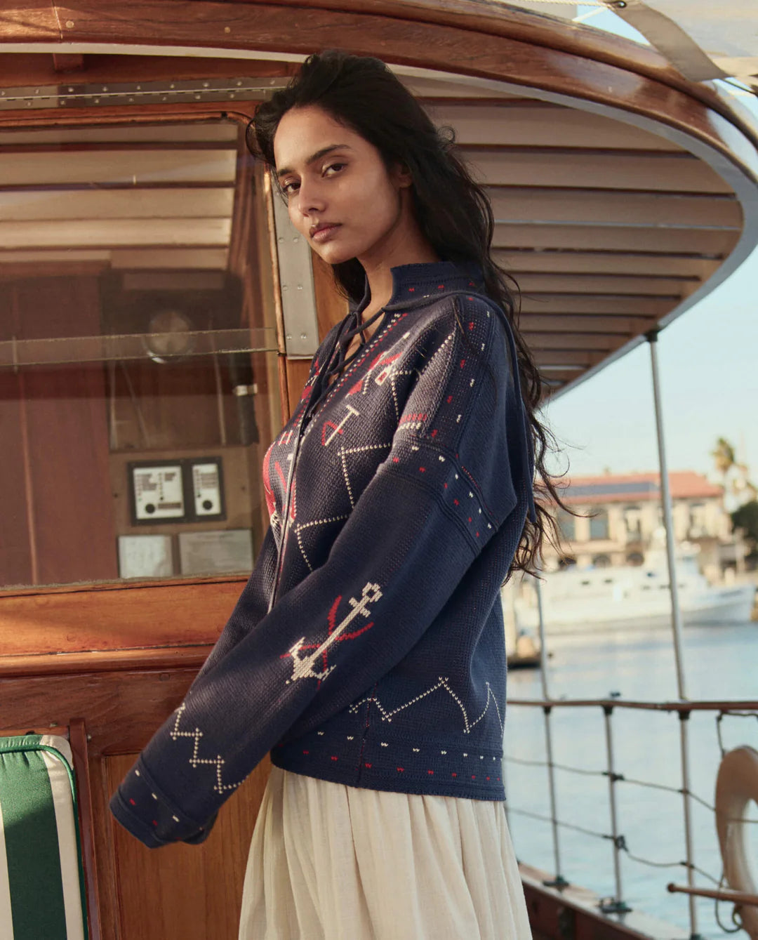 Woman wearing a patterned navy sweater on a boat