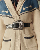 Close-up of a person wearing a patterned coat with a belt and buckle.