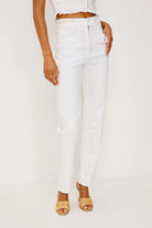 Person wearing white pants on a plain background