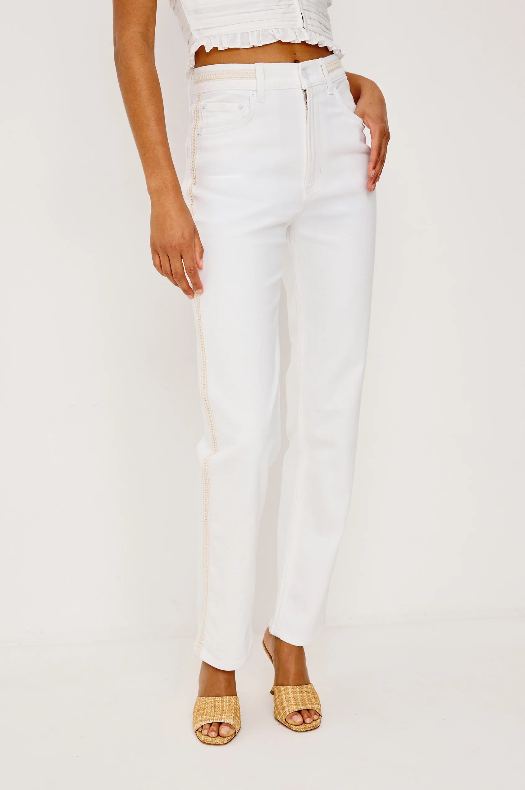 Person wearing white pants on a plain background