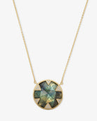 Necklace with a green gemstone pendant on a white background