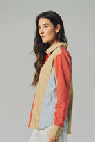 Woman wearing a colorful, patterned shirt against a plain background