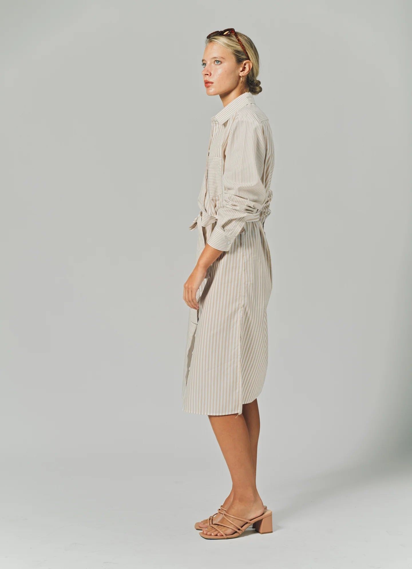 Woman wearing a beige dress against a plain background