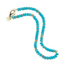 Turquoise beaded necklace with gold accents on a white background