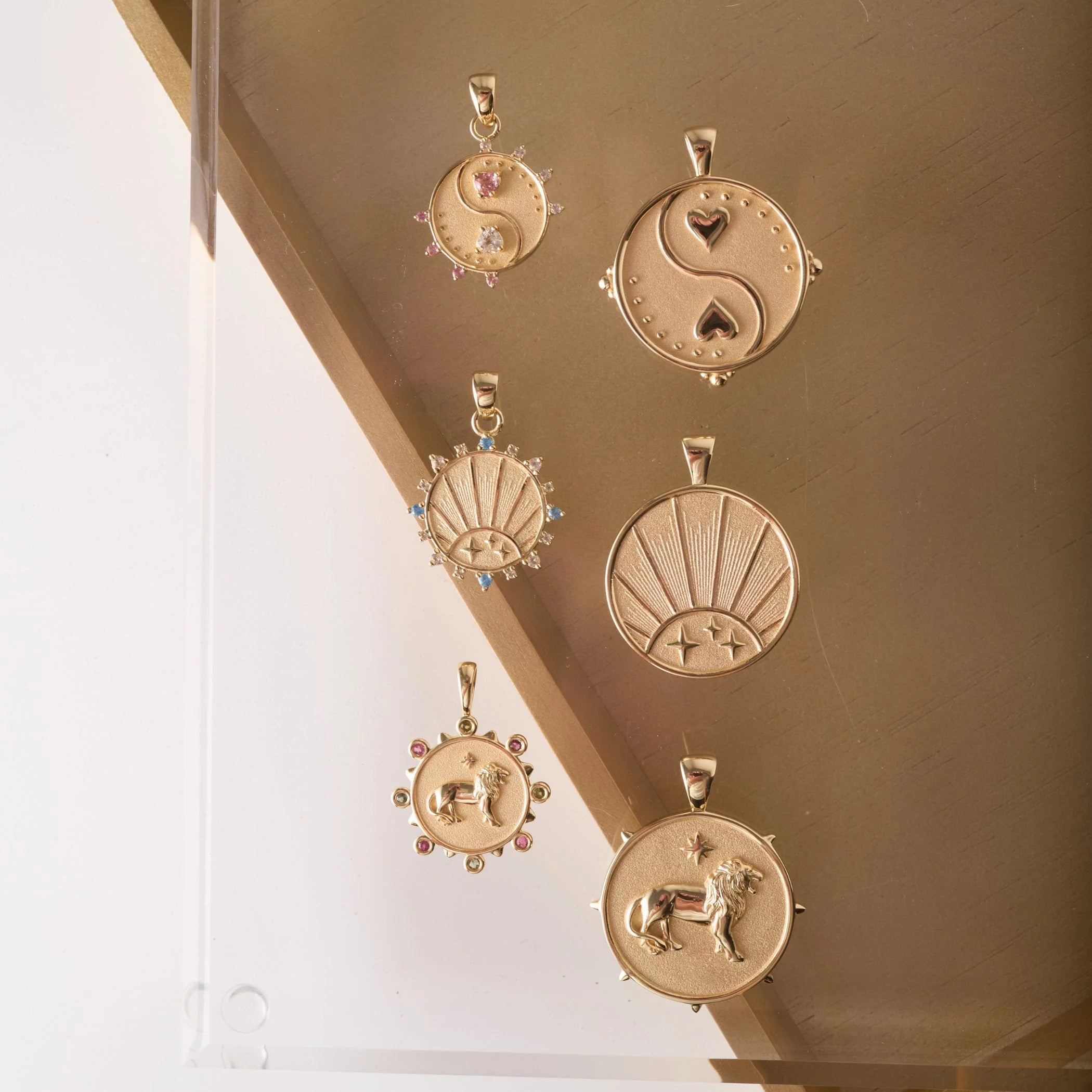 Set of gold pendants on a reflective surface