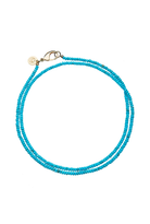 A double-strand turquoise beaded necklace with a gold clasp and a small round gold charm, displayed on a clean white background.