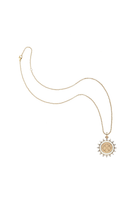 A delicate gold chain necklace featuring a circular pendant with a sunburst border and a central geometric pattern, displayed on a clean white background.