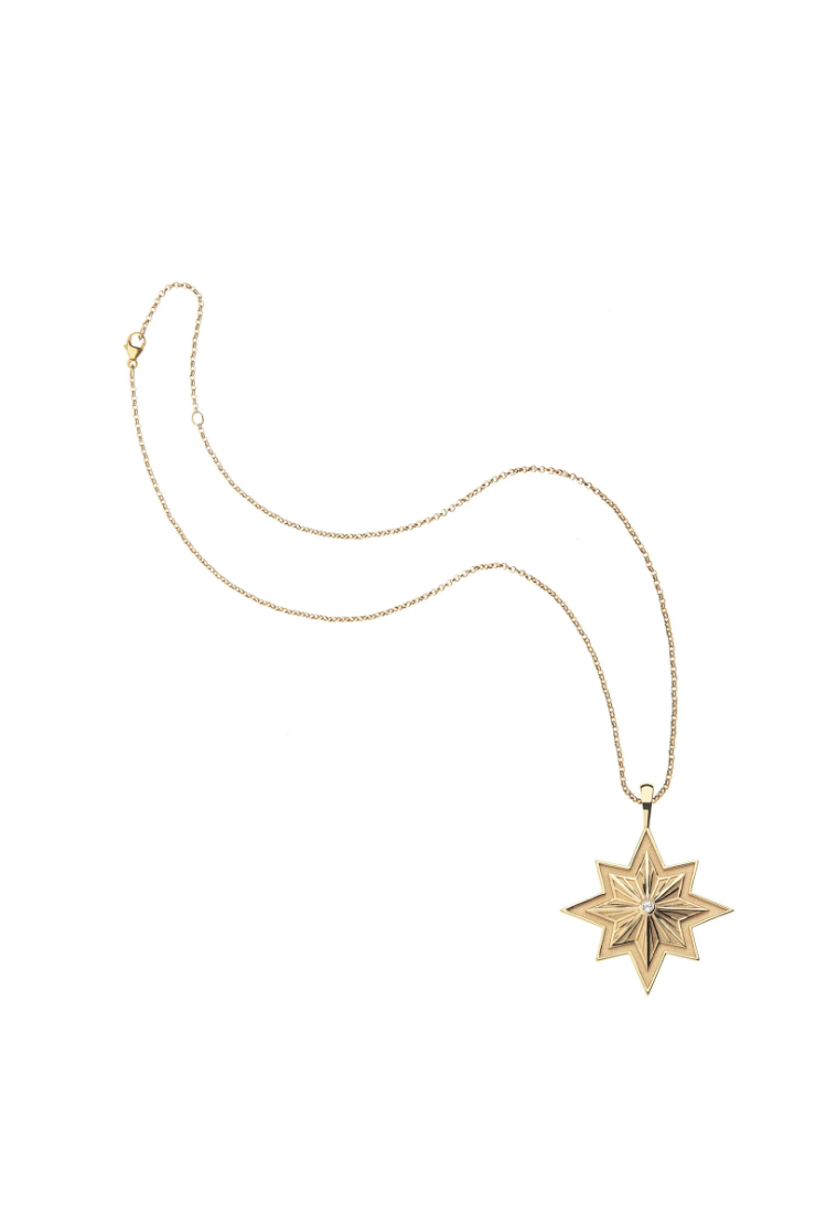 A gold necklace featuring a star-shaped pendant with a textured, layered starburst design and a small central clear gemstone, displayed on a clean white background.