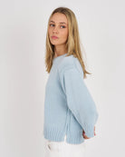 Woman wearing a light blue sweater against a white background