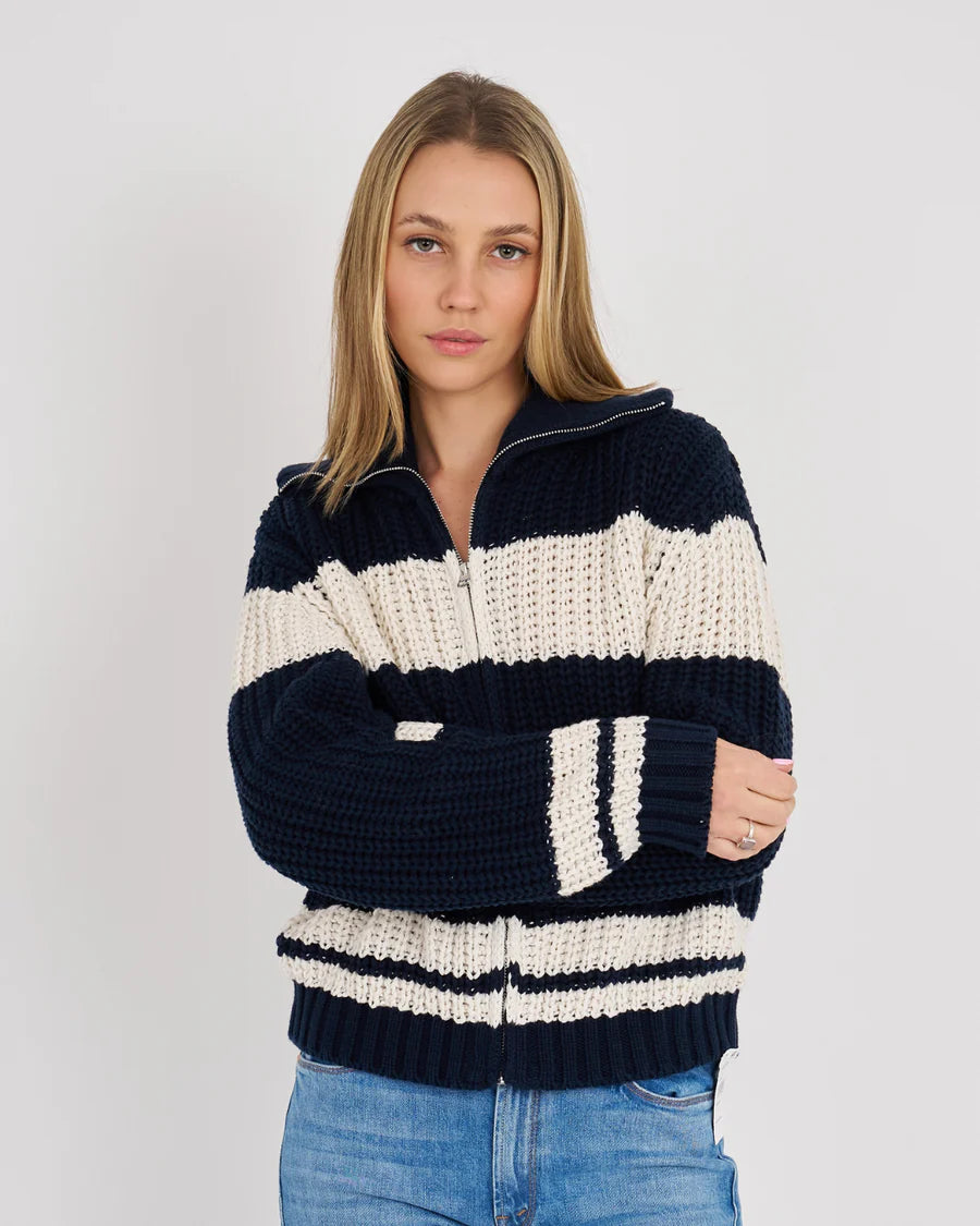 Person wearing a navy and white striped sweater on a plain background