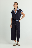 Woman wearing a navy outfit with a white background