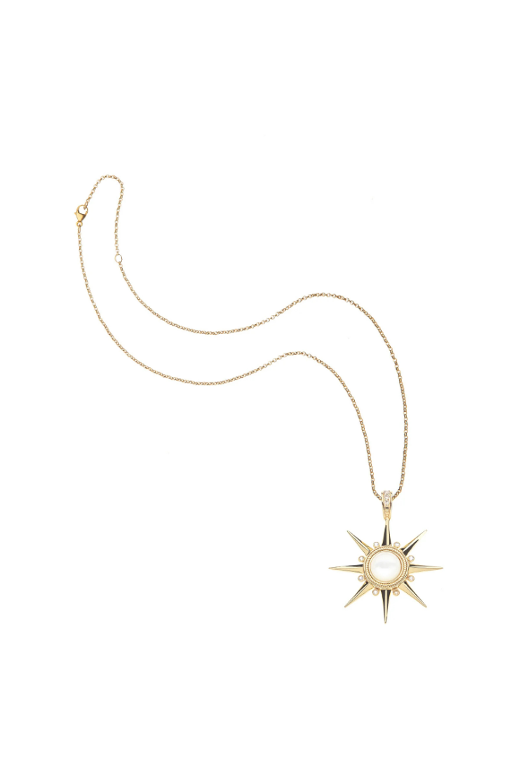 A gold starburst pendant necklace with a central white pearl, displayed on a clean white background.