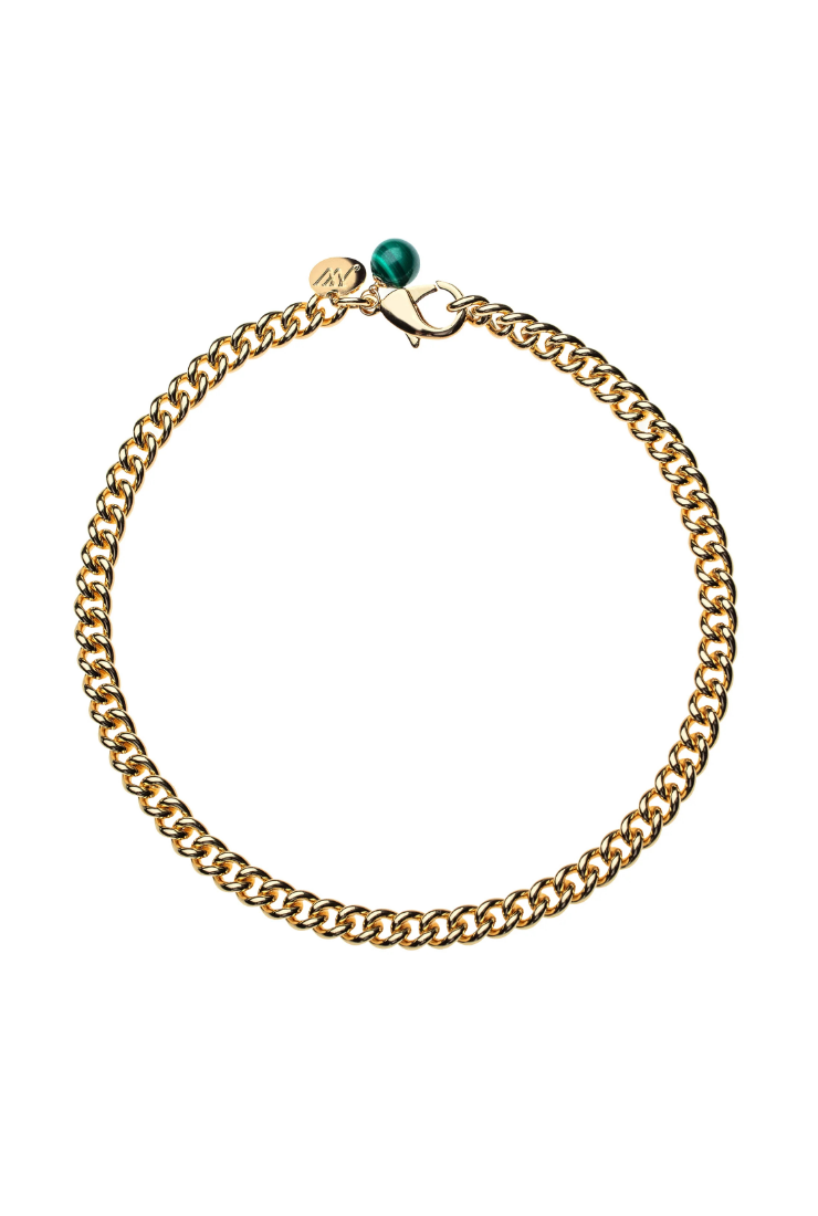 A gold-toned curb chain bracelet with a small green bead and a silver-toned lobster clasp, displayed on a clean white background.