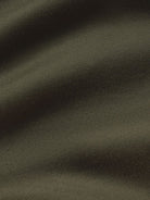 A close-up of dark olive green fabric with soft folds and a fine knit texture.