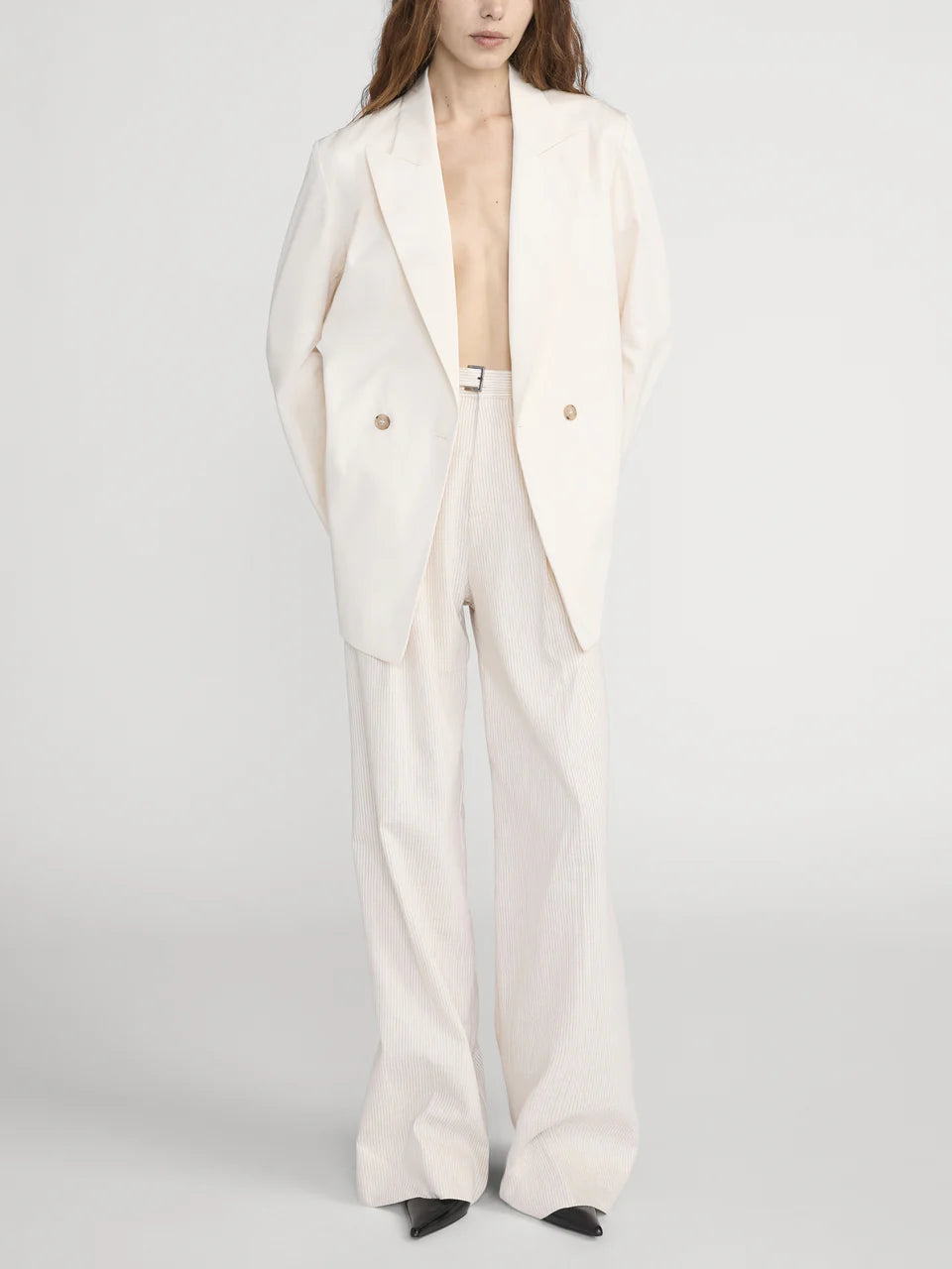 Person wearing a white suit on a plain background