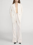 Person wearing a white suit on a plain background