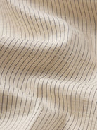 Close-up of beige fabric with subtle black line pattern