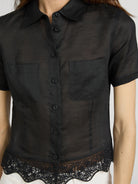 Black short-sleeve shirt with lace trim on a plain background