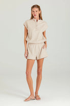 Woman wearing a beige outfit on a white background