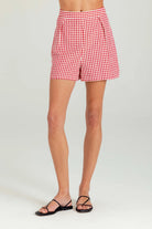 Red and white checkered shorts worn by a person on a plain background