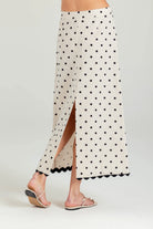 White skirt with black polka dots and a slit on a white background
