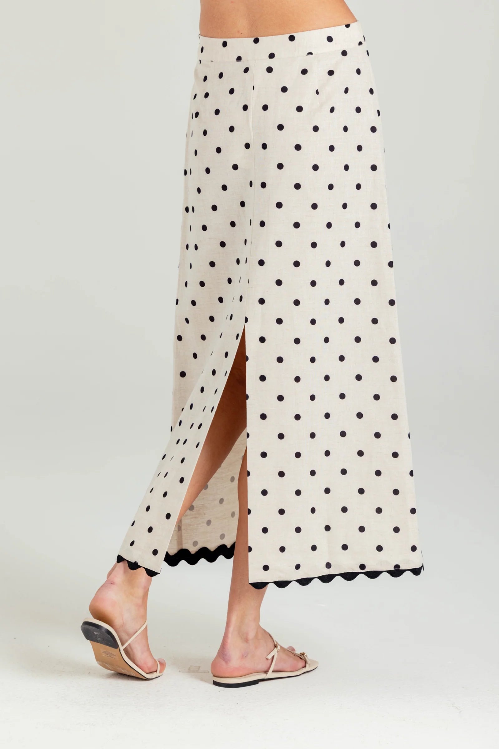 White skirt with black polka dots and a slit on a white background