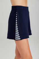 Navy blue skirt with white striped side panel on a gray background