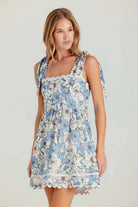 Woman wearing a floral dress on a plain background